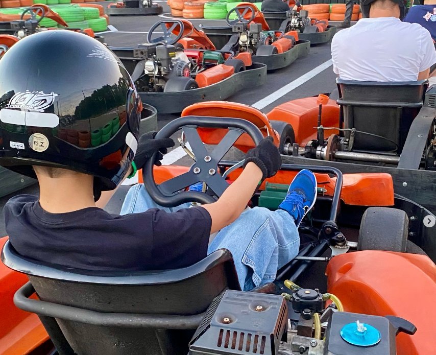 Criança pilotando um kart no grid da Arena Kart Pulse