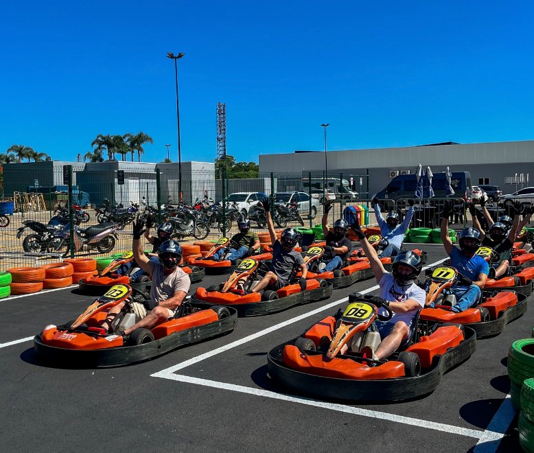 Grupo de pilotos comemorando nos karts da Arena Kart Pulse
