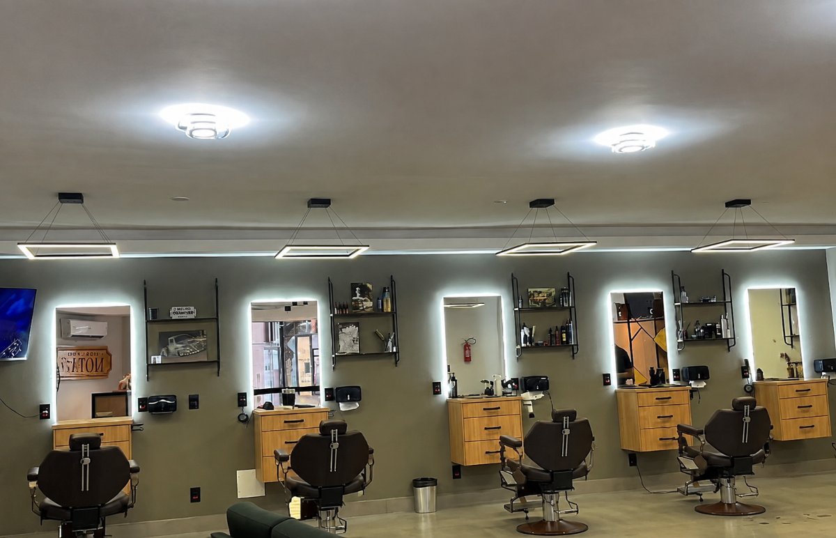 Salão da Barbearia Mota77 com cadeiras de barbeiro e espelhos