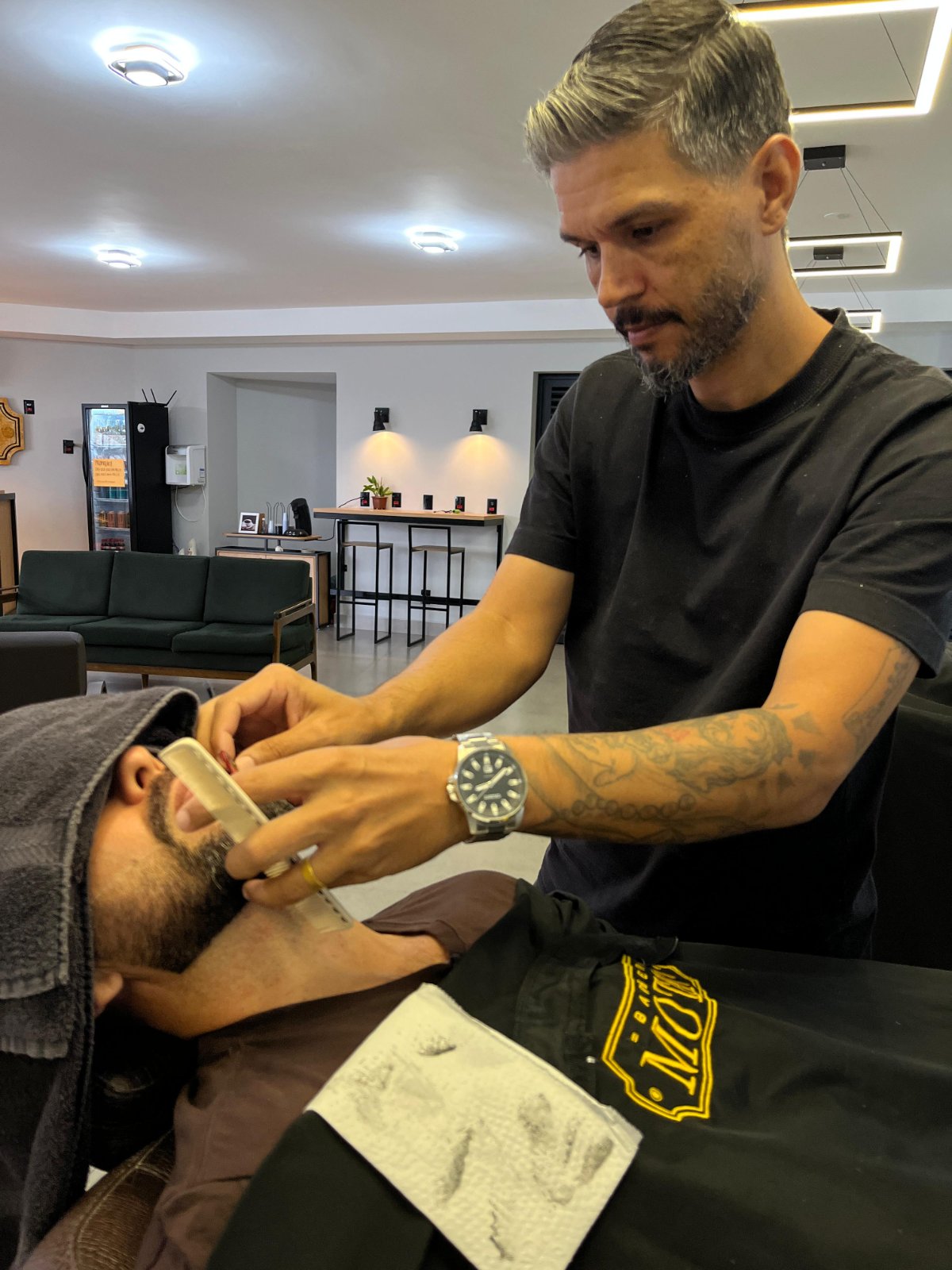 Barbeiro fazendo o acabamento da barba na Mota77